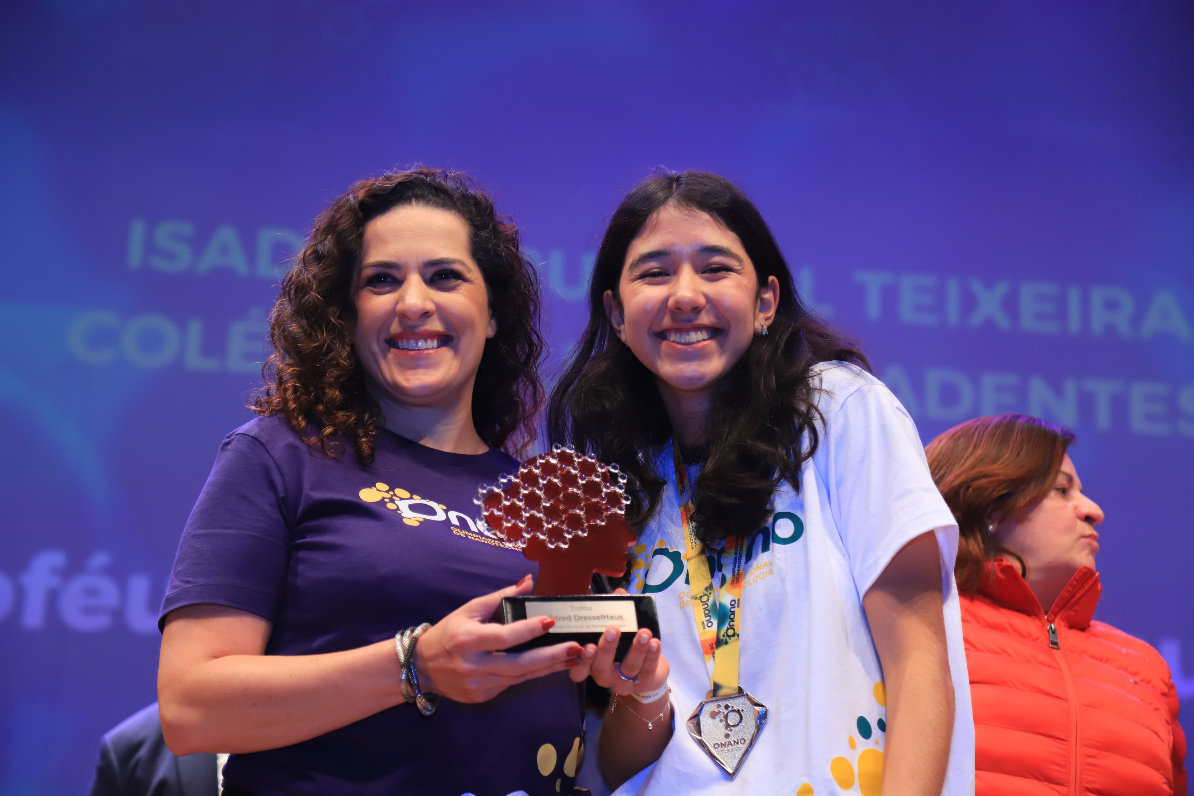 Medalhista recebendo o troféu Mildred Dresselhaus na premiação da ONANO